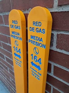 Postes de señalización para red de gas en polipropileno Maderplast, color amarillo de alta visibilidad con rotulación azul para identificar tuberías de gas de media presión.